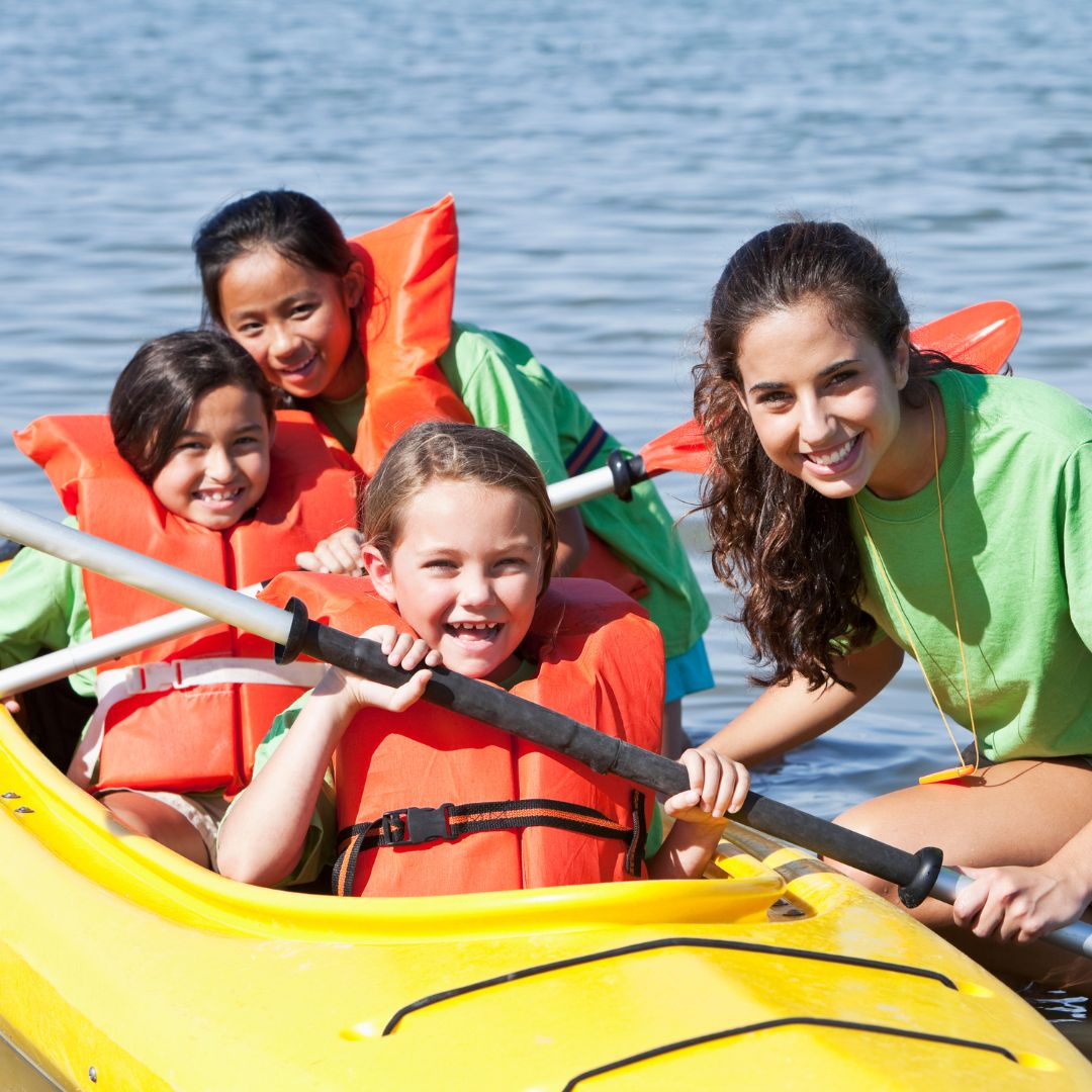 counselor with campers in kayak